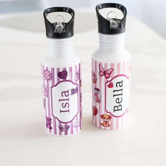 Two personalized water bottles with names 'Isla' and 'Bella' on a white surface.